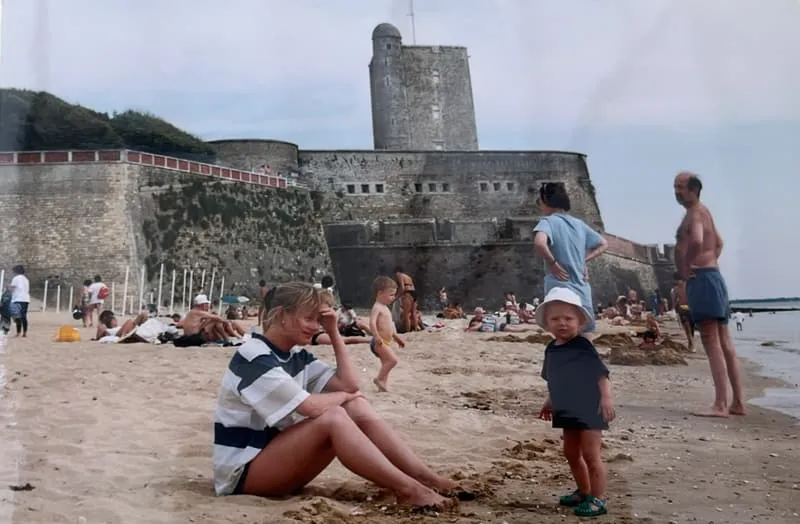 The same fort, an earlier decade — a busy summer beach below it