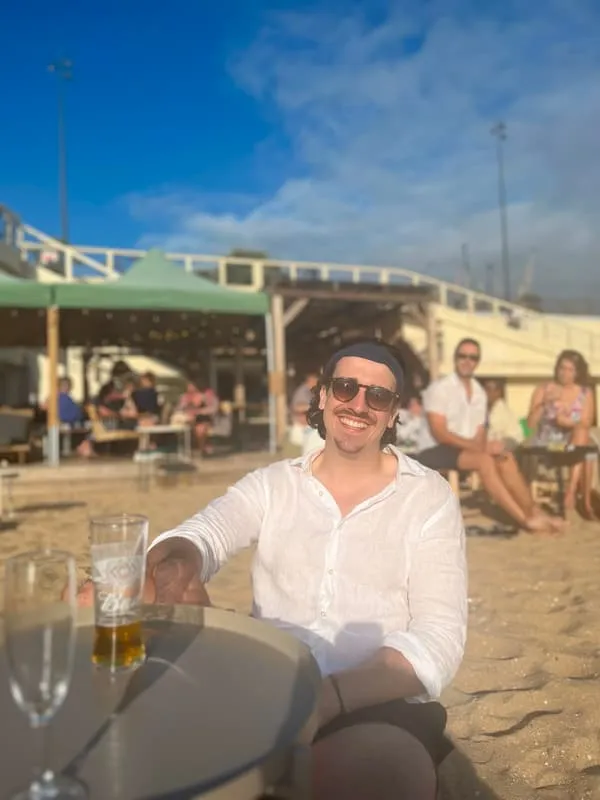 Jonny with a beer at the beach bar